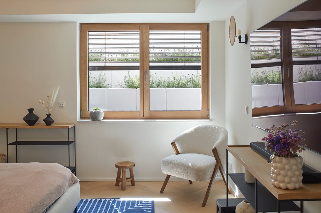 Wood tilt-turn window in a bedroom interior
