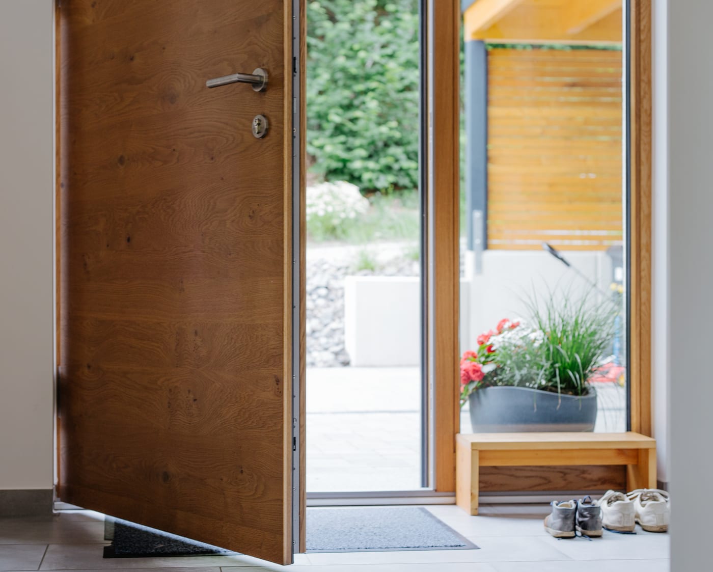 Solid wood front door open onto a garden entrance