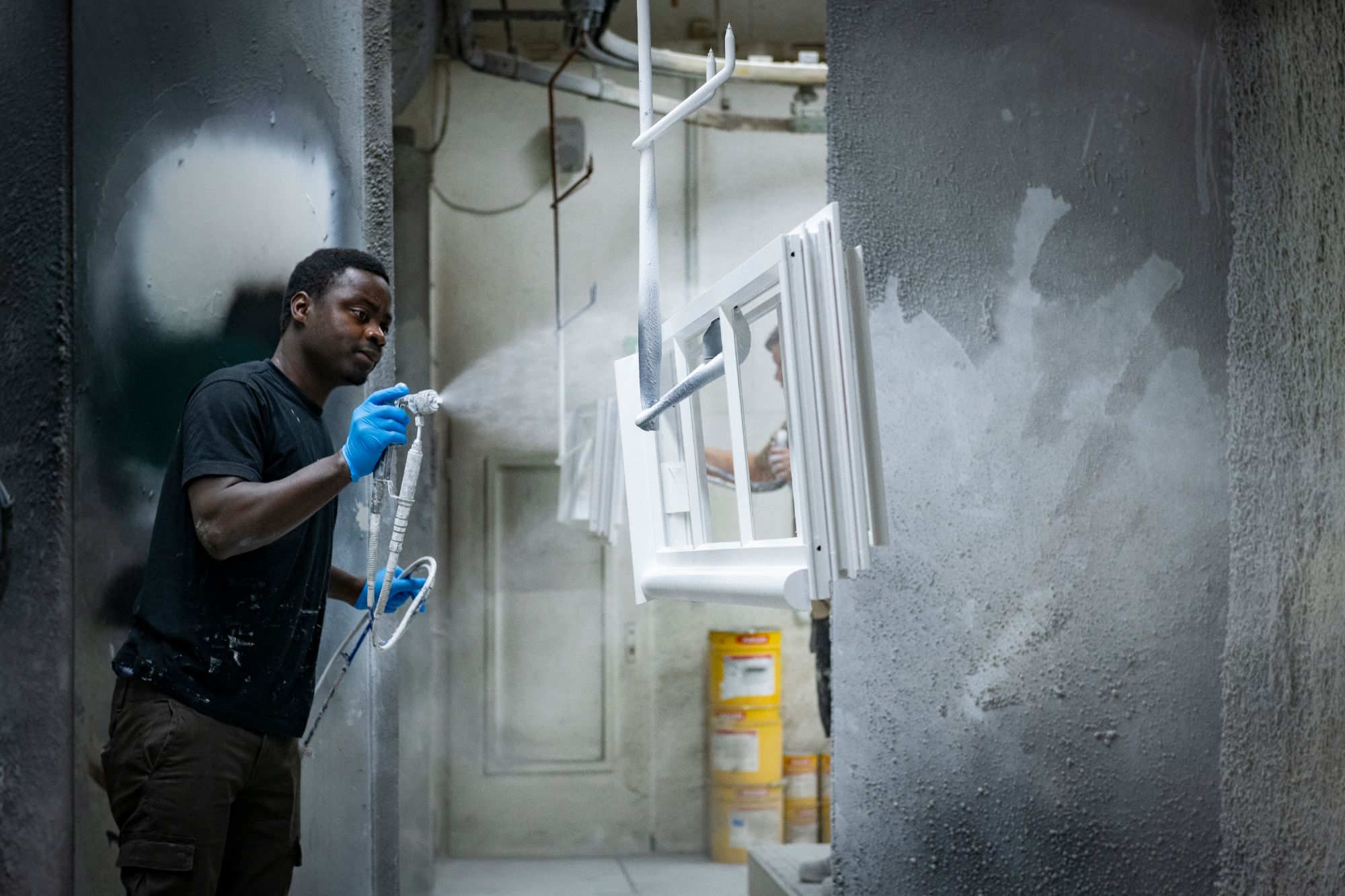 Sorpetaler craftsman spray-finishing a window frame