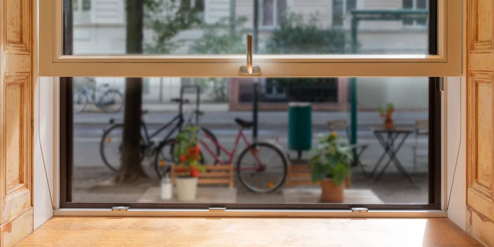 Detail of a Sorpetaler vertical sliding window handle, open onto a street view