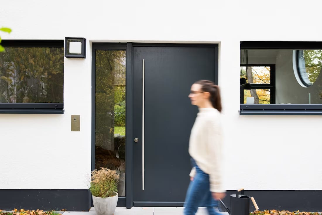 A modern front door with a round window visible inside