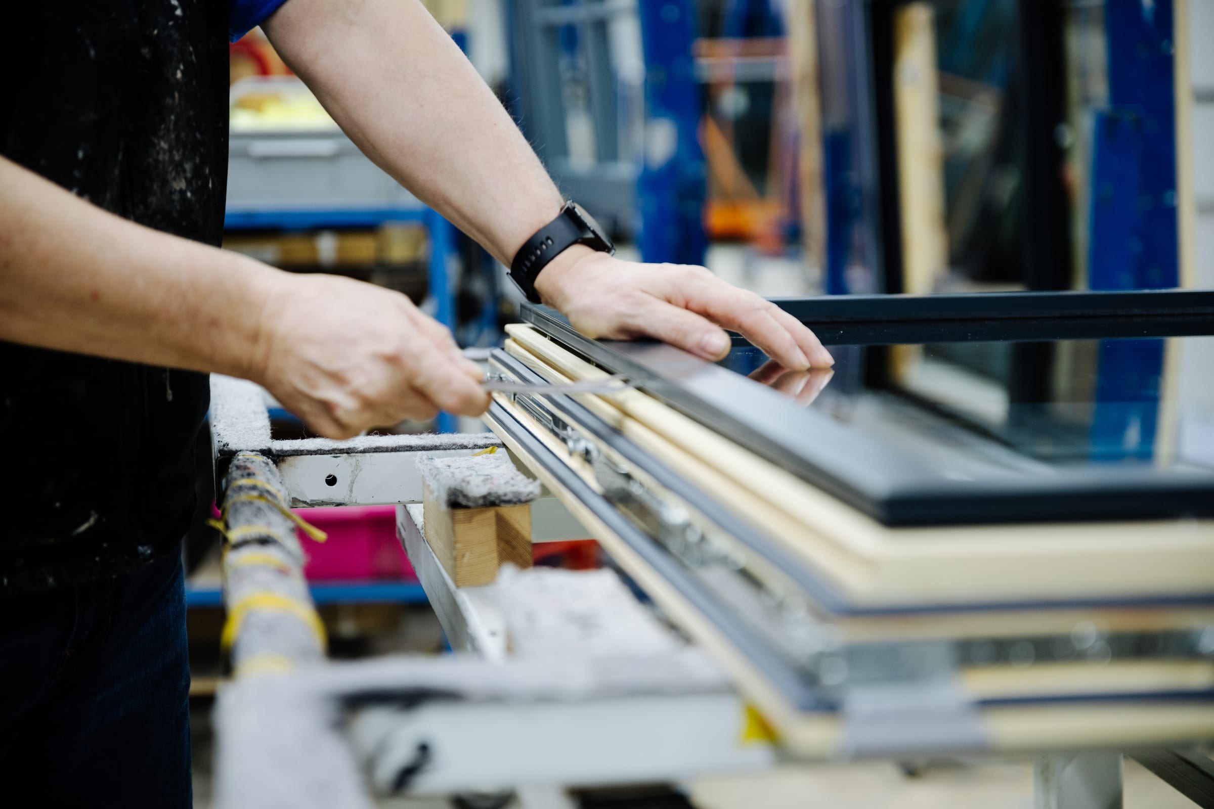 Close-up of a craftsman's hands precisely measuring a window frame in the Sorpetaler factory