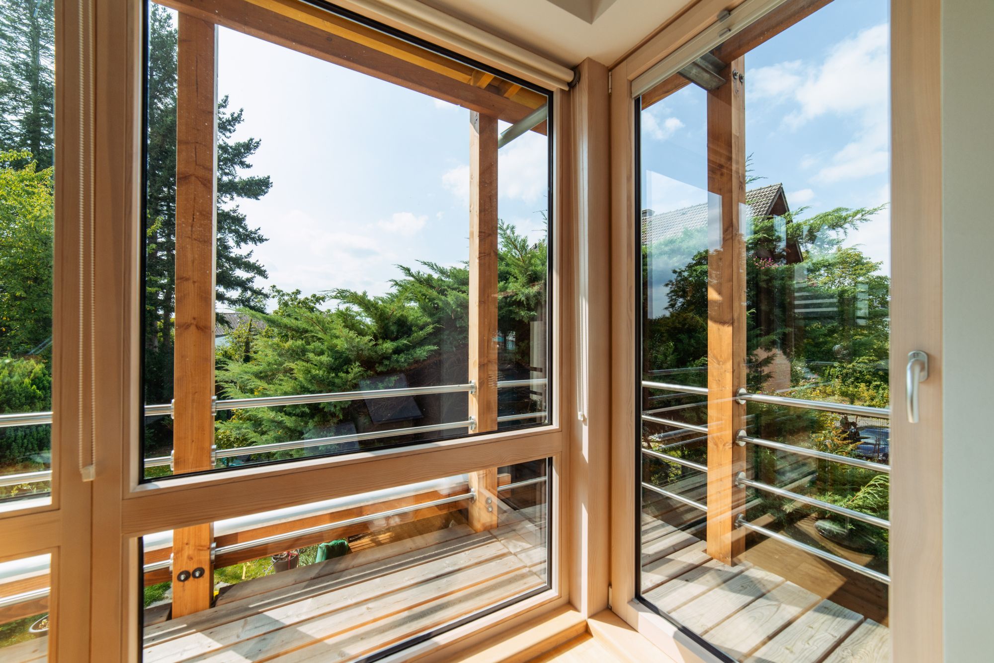 Wood-framed corner windows and balcony door opening onto a wraparound balcony