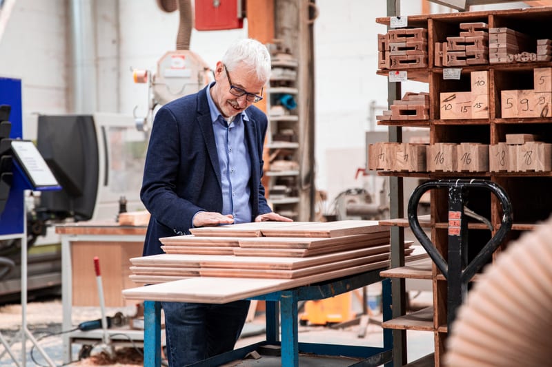 Eduard Appelhans inspecting wood boards in the Sorpetaler workshop